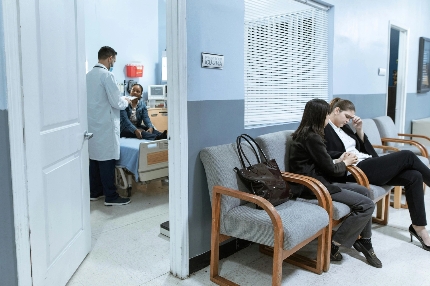 Alltagsengel plus - Alltagshelfer - Dieses Bild zeigt einen Moment in einem Krankenhaus, in dem ein Arzt einen Patienten auf der Intensivstation betreut, während andere in der Nähe warten.